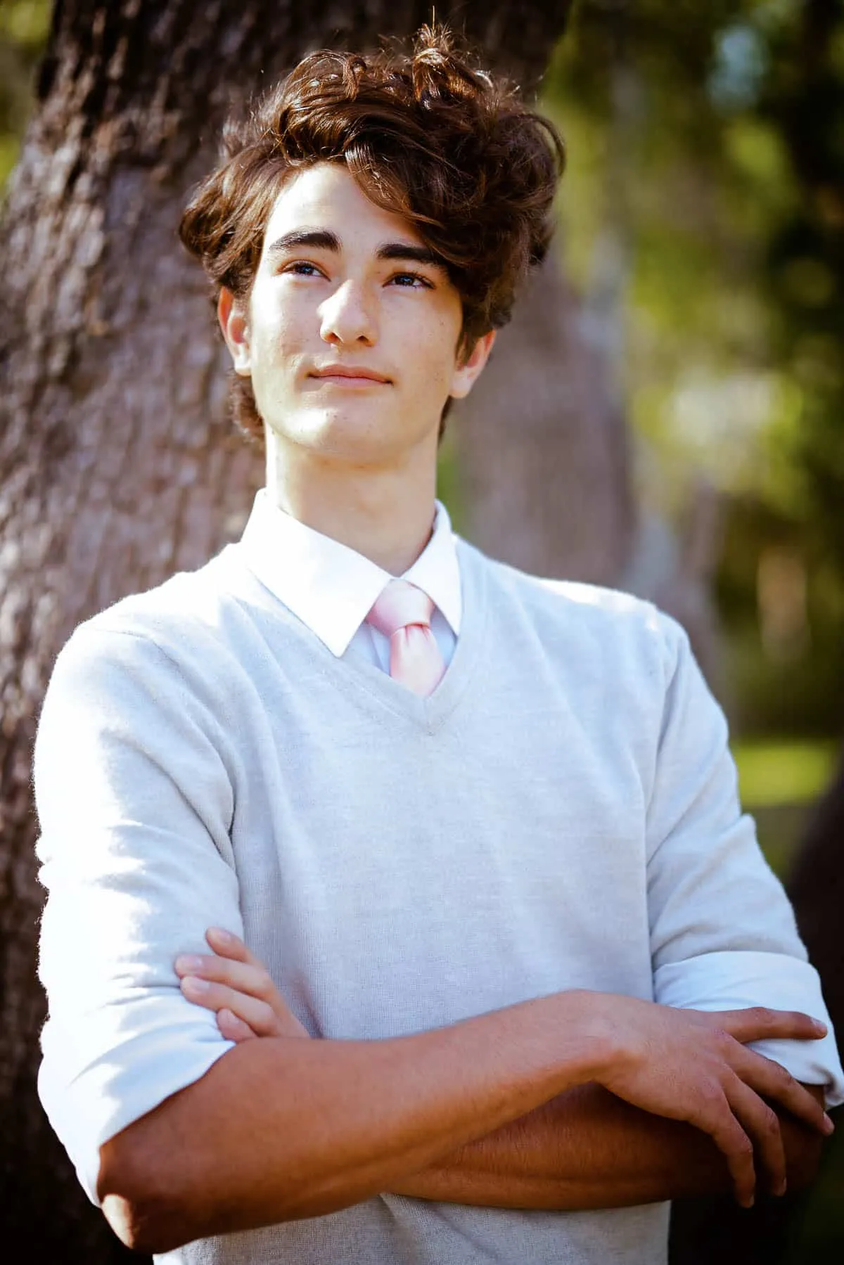 High school senior posing with his dog in a wooded area near Sarasota