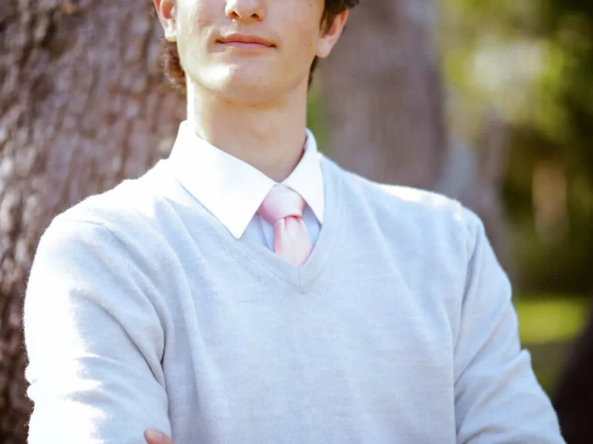High school senior posing with his dog in a wooded area near Sarasota