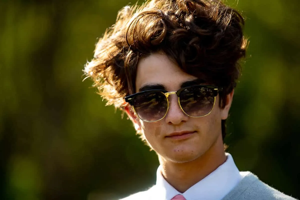 High school senior posing with his dog in a wooded area near Sarasota
