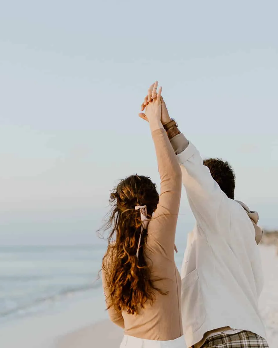 Couple walking together along Siesta Beach on a cool, hazy day