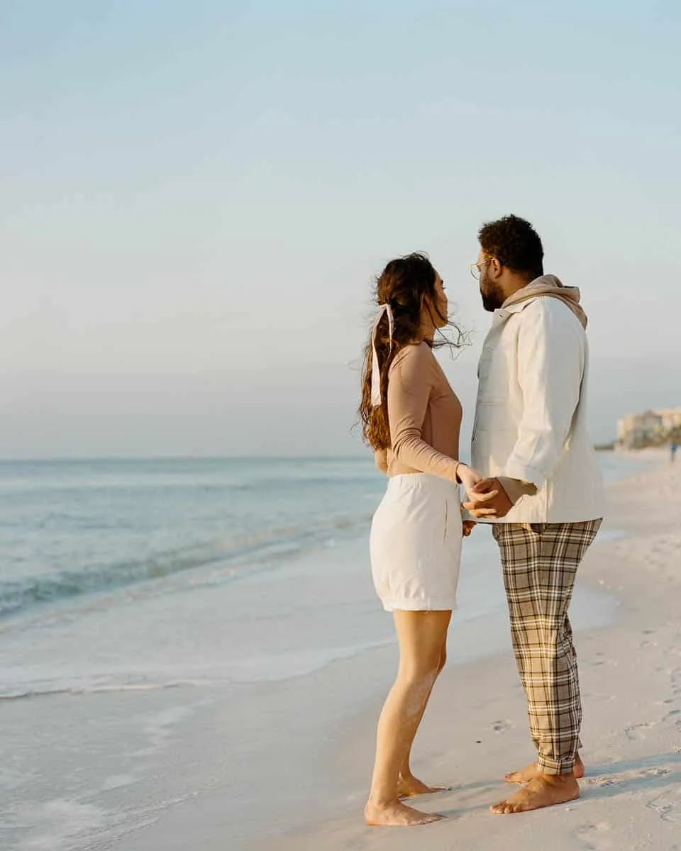 Couple walking together along Siesta Beach on a cool, hazy day