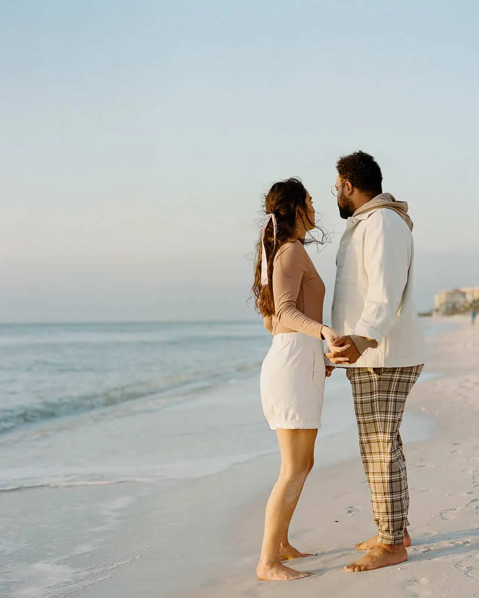 Couple walking together along Siesta Beach on a cool, hazy day