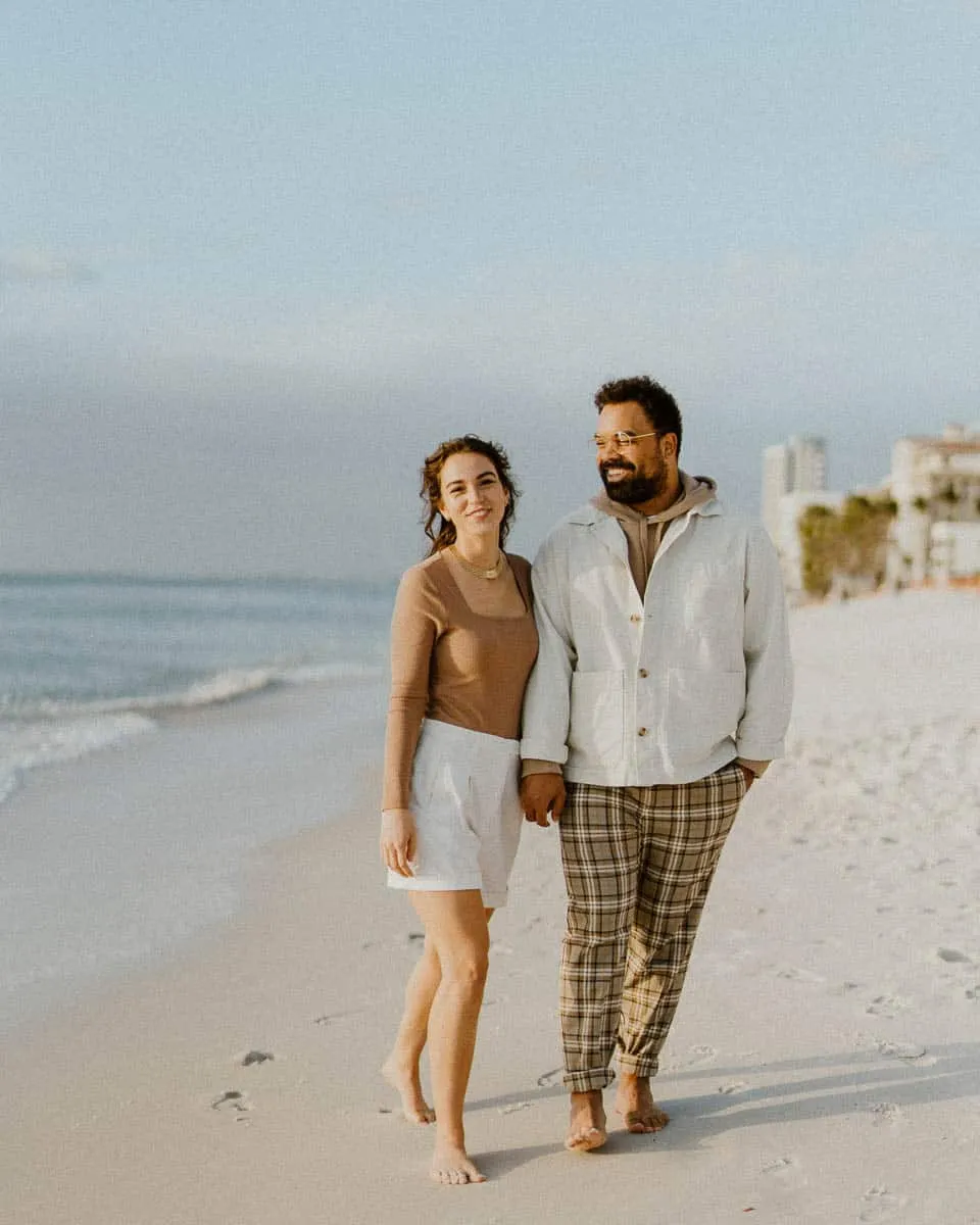 Couple walking together along Siesta Beach on a cool, hazy day