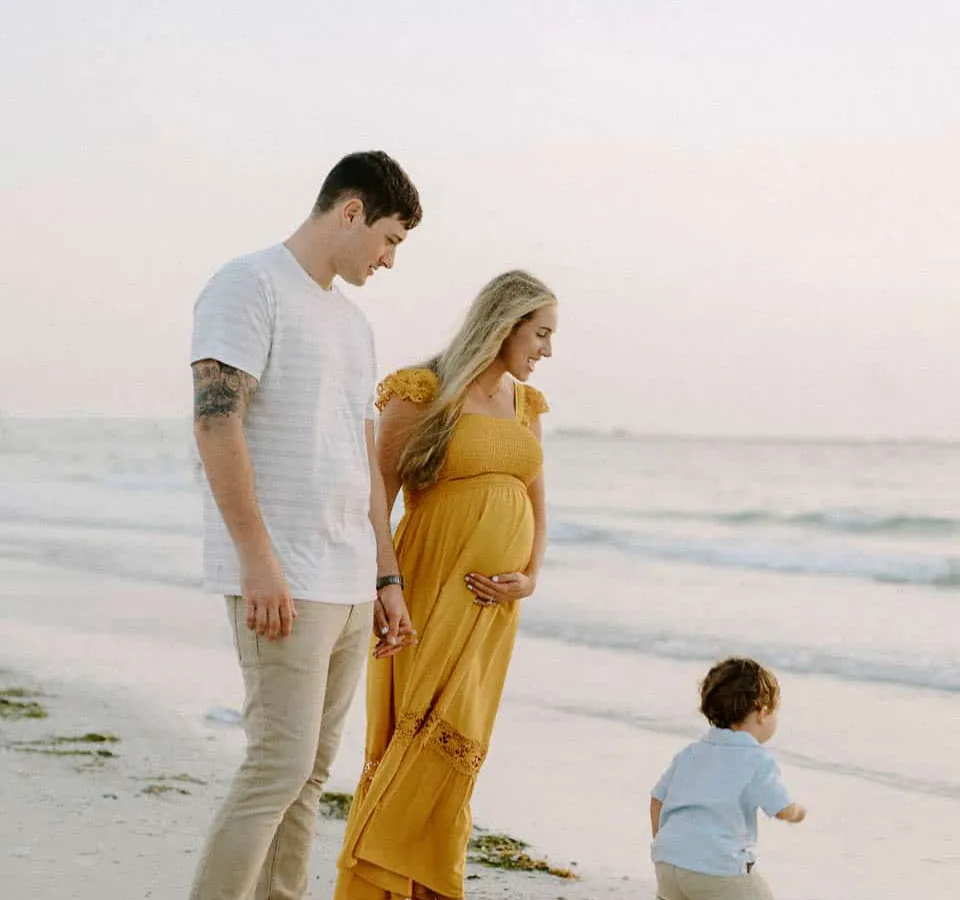 Family of three together on the sand at Siesta Beach