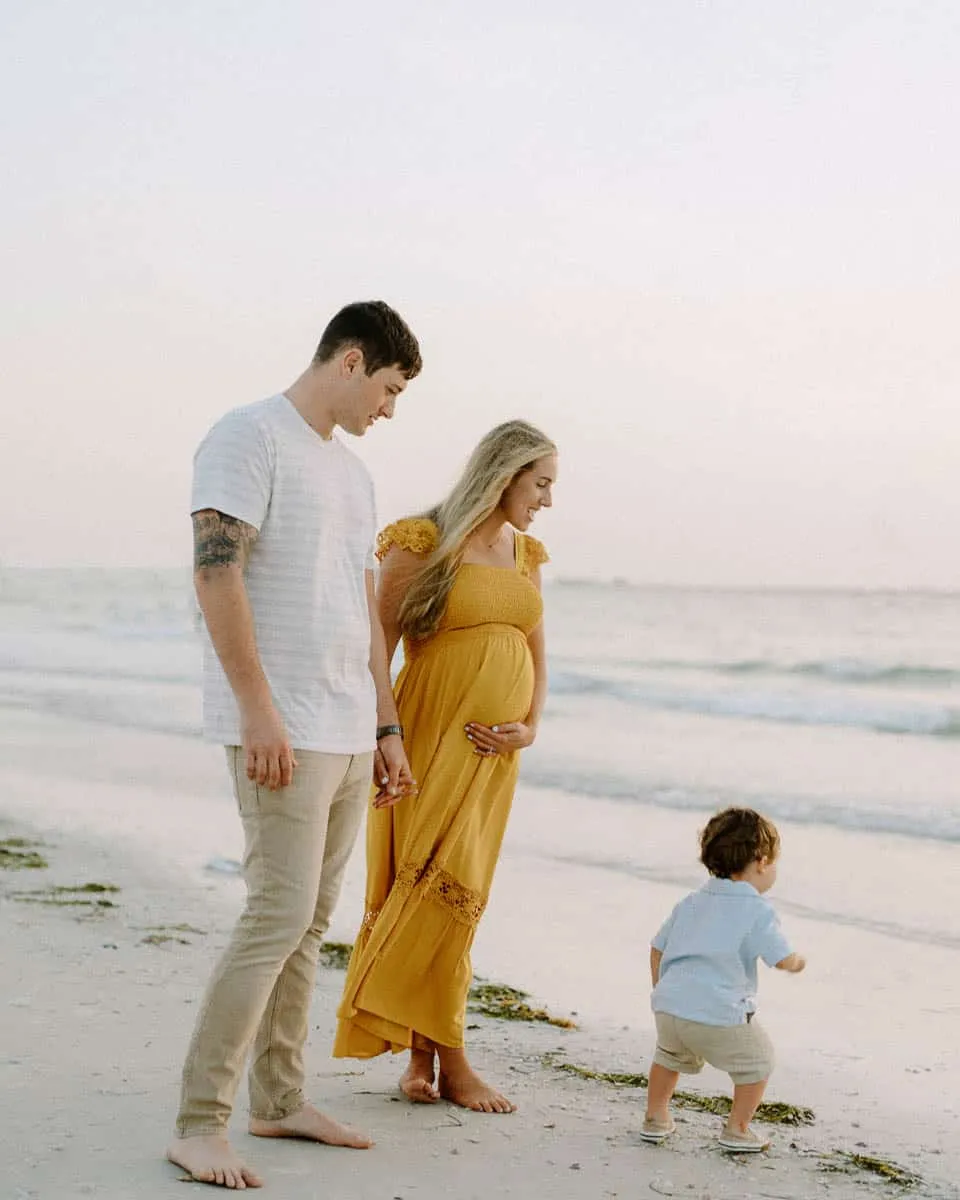 Family of three together on the sand at Siesta Beach