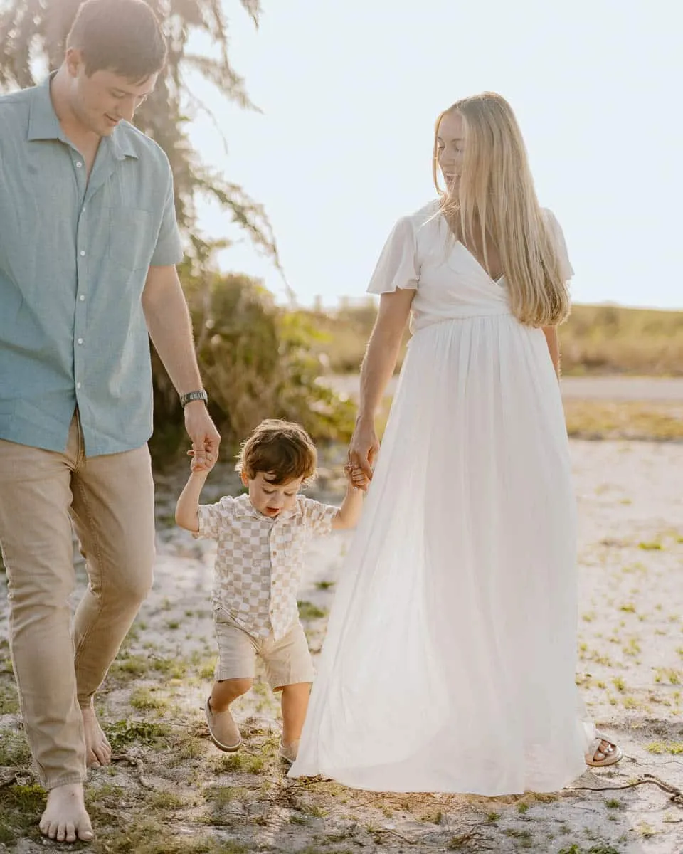 Family of three together on the sand at Siesta Beach