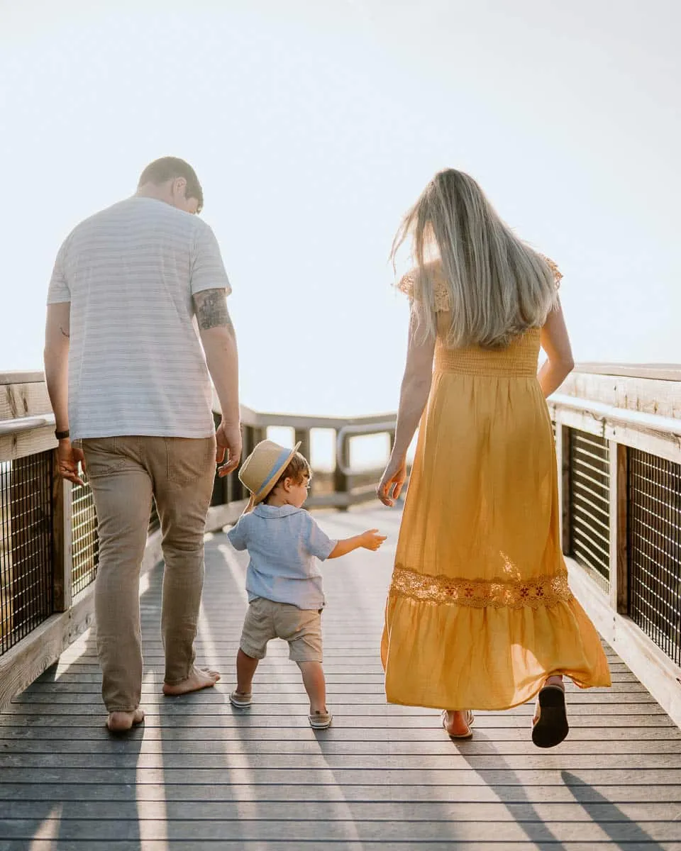 Family of three together on the sand at Siesta Beach