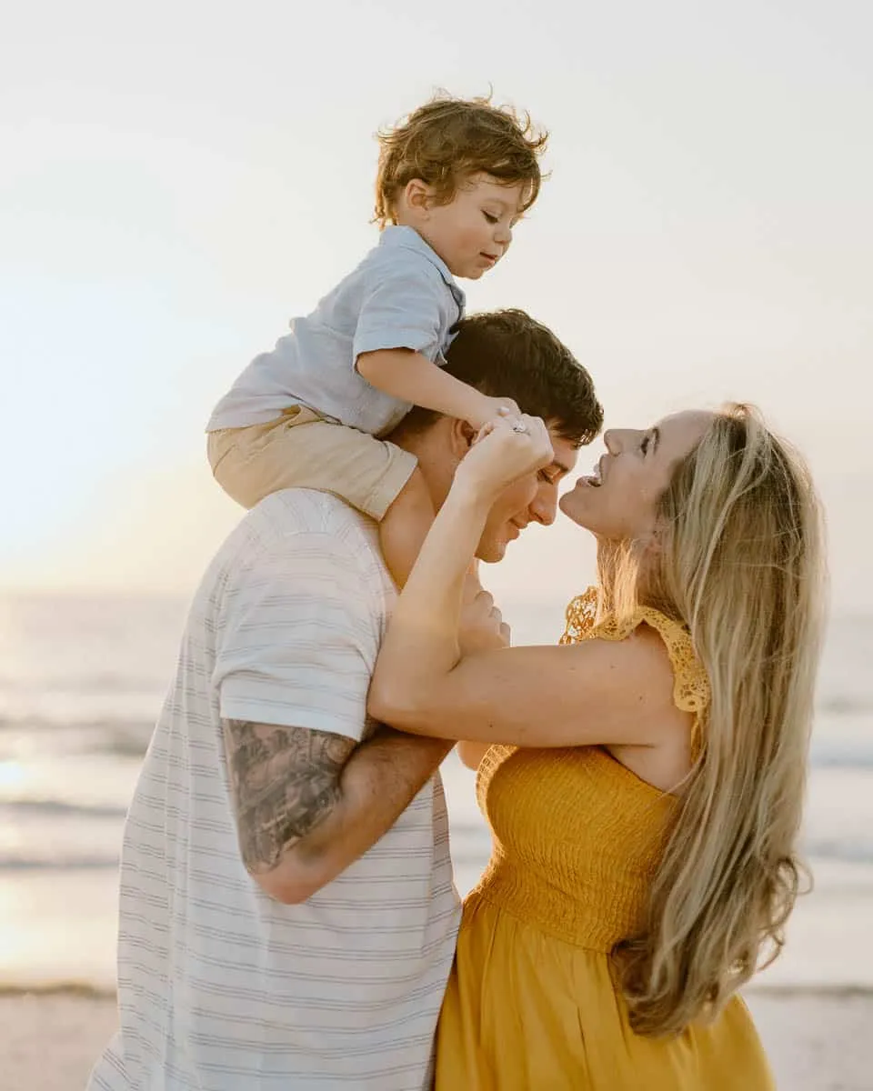 Family of three together on the sand at Siesta Beach
