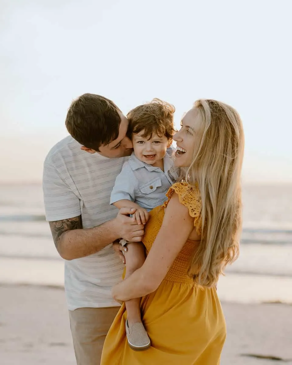 Family of three together on the sand at Siesta Beach