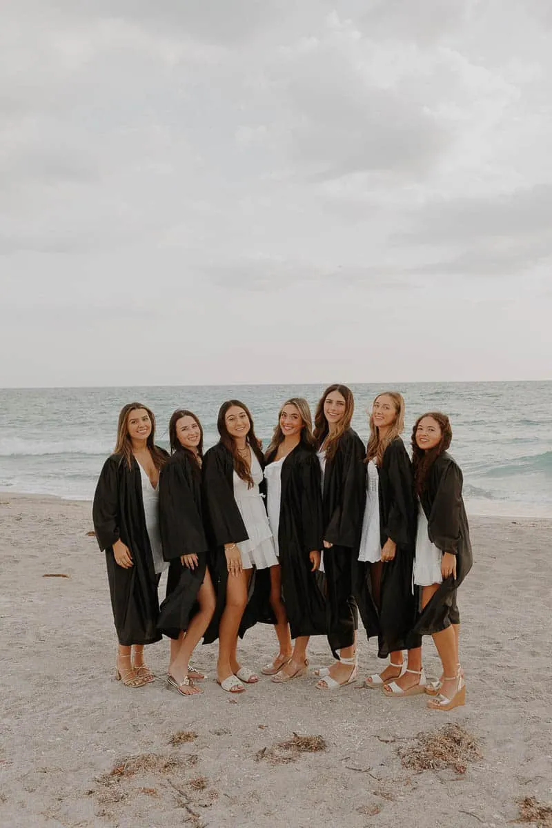 Group of graduating senior girls laughing together on the beach at Siesta Key