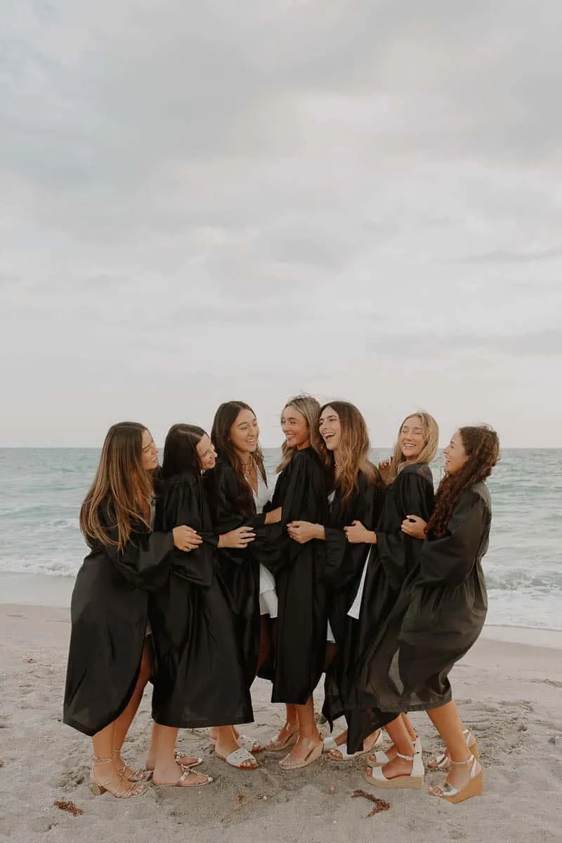 Group of graduating senior girls laughing together on the beach at Siesta Key