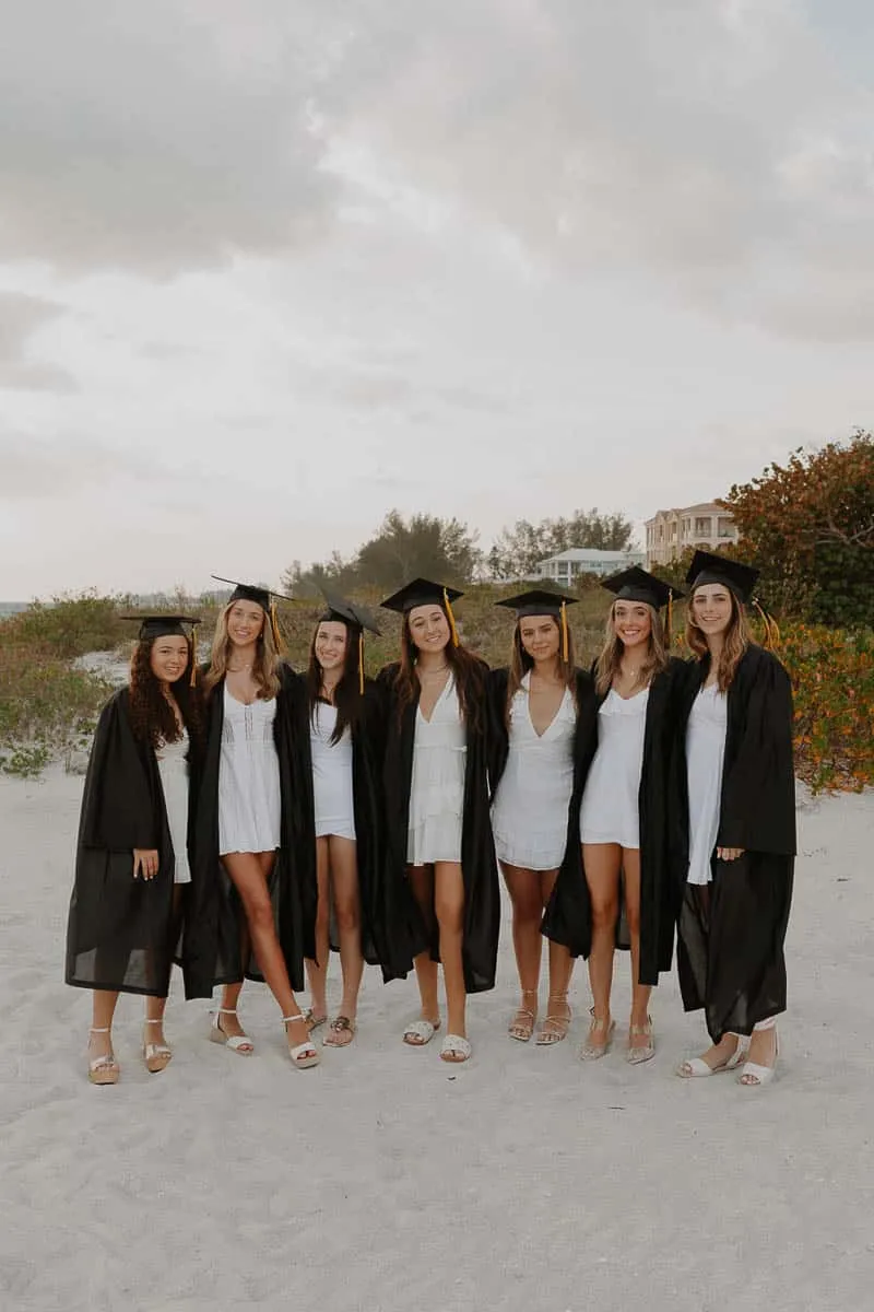 Group of graduating senior girls laughing together on the beach at Siesta Key