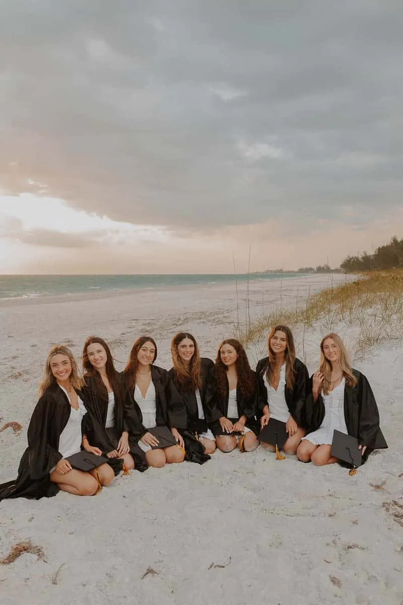 Group of graduating senior girls laughing together on the beach at Siesta Key