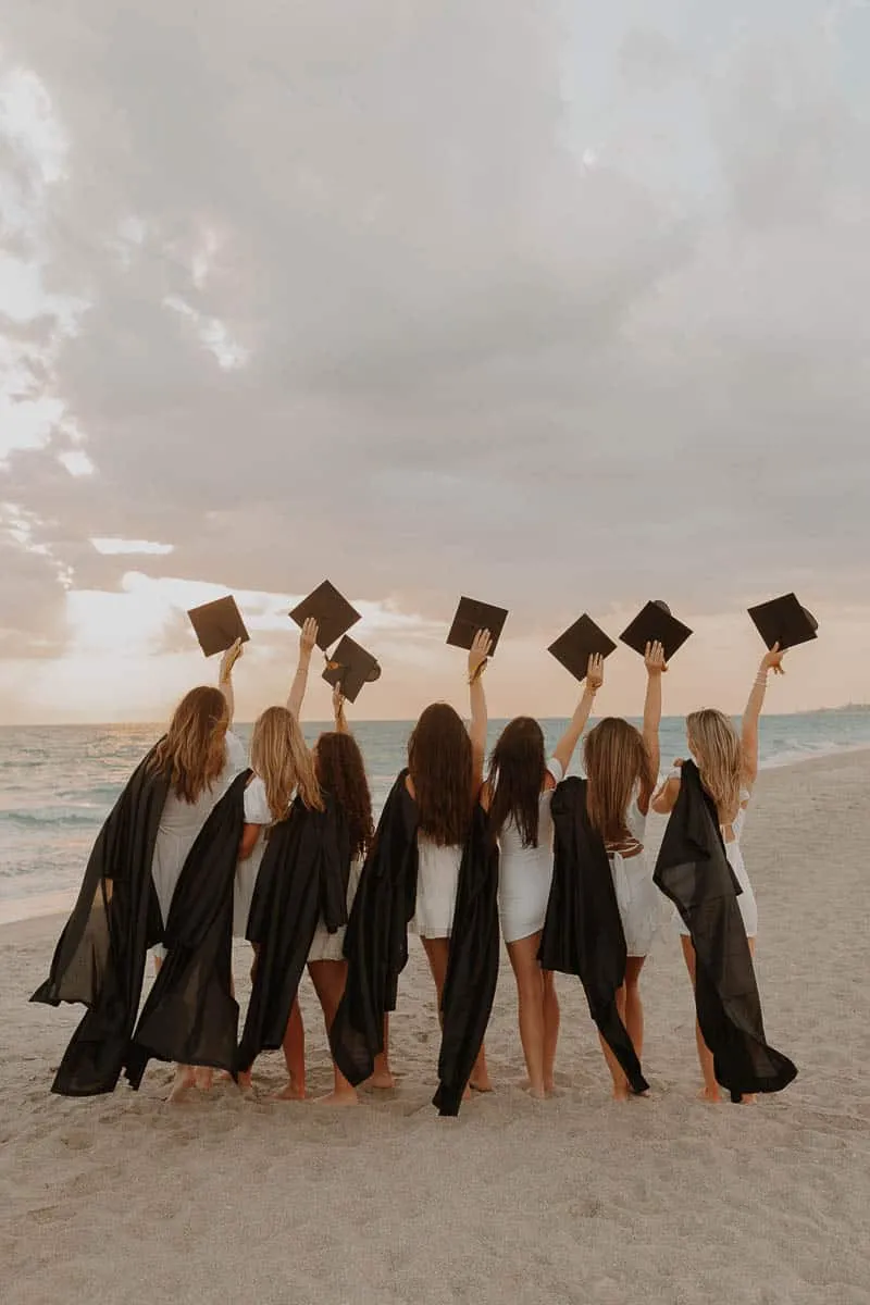 Group of graduating senior girls laughing together on the beach at Siesta Key