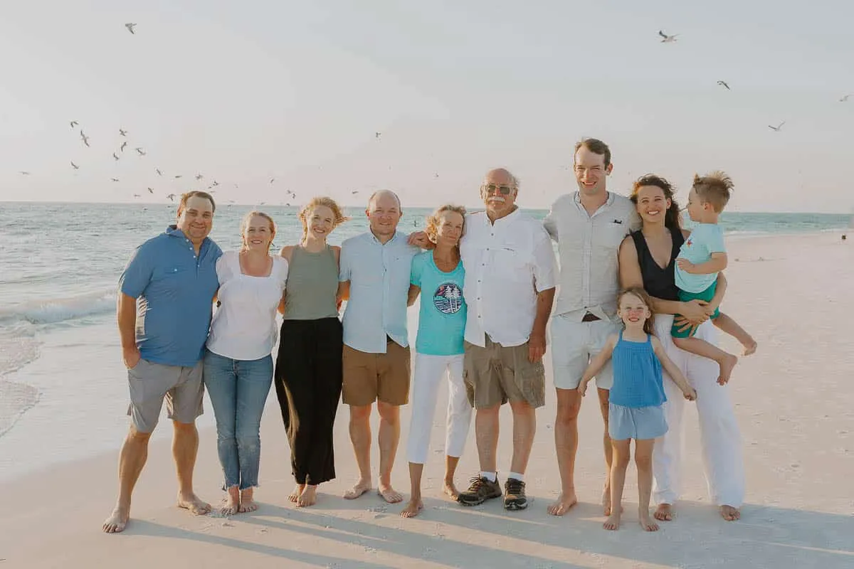 Three generations of a family together on the sand at Siesta Beach in the early evening
