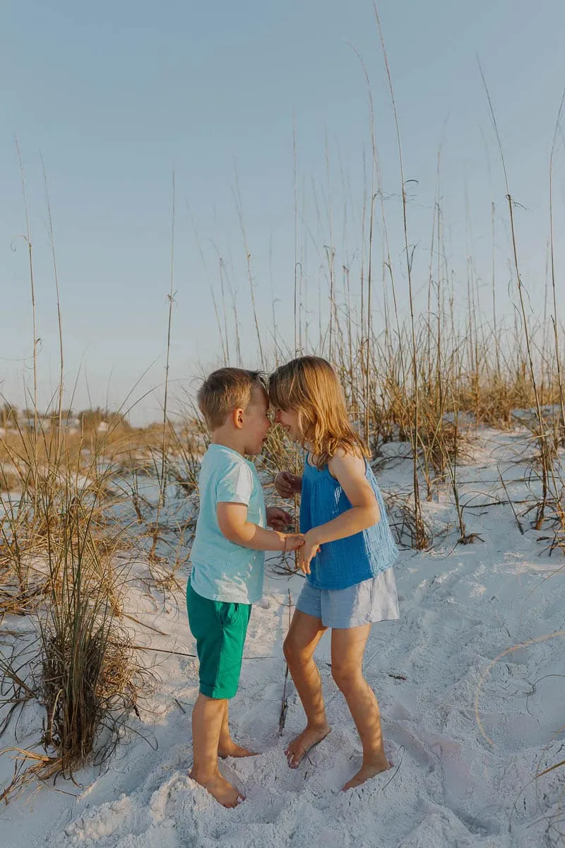 Three generations of a family together on the sand at Siesta Beach in the early evening