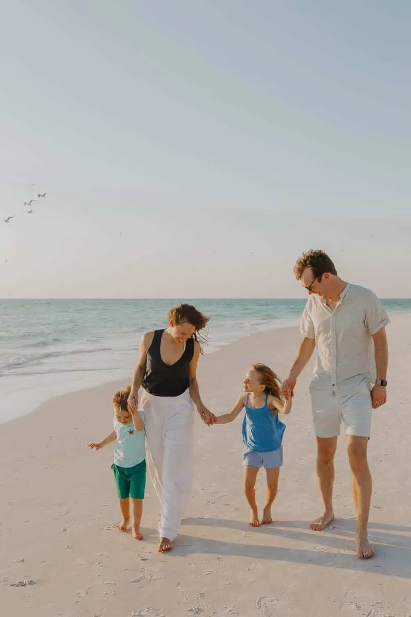 Three generations of a family together on the sand at Siesta Beach in the early evening
