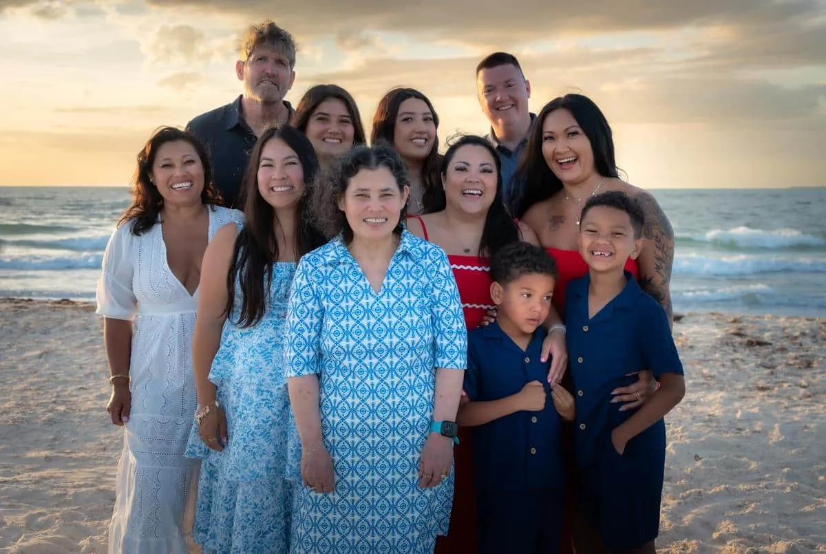 Multi-generational family on vacation posing together on the beach