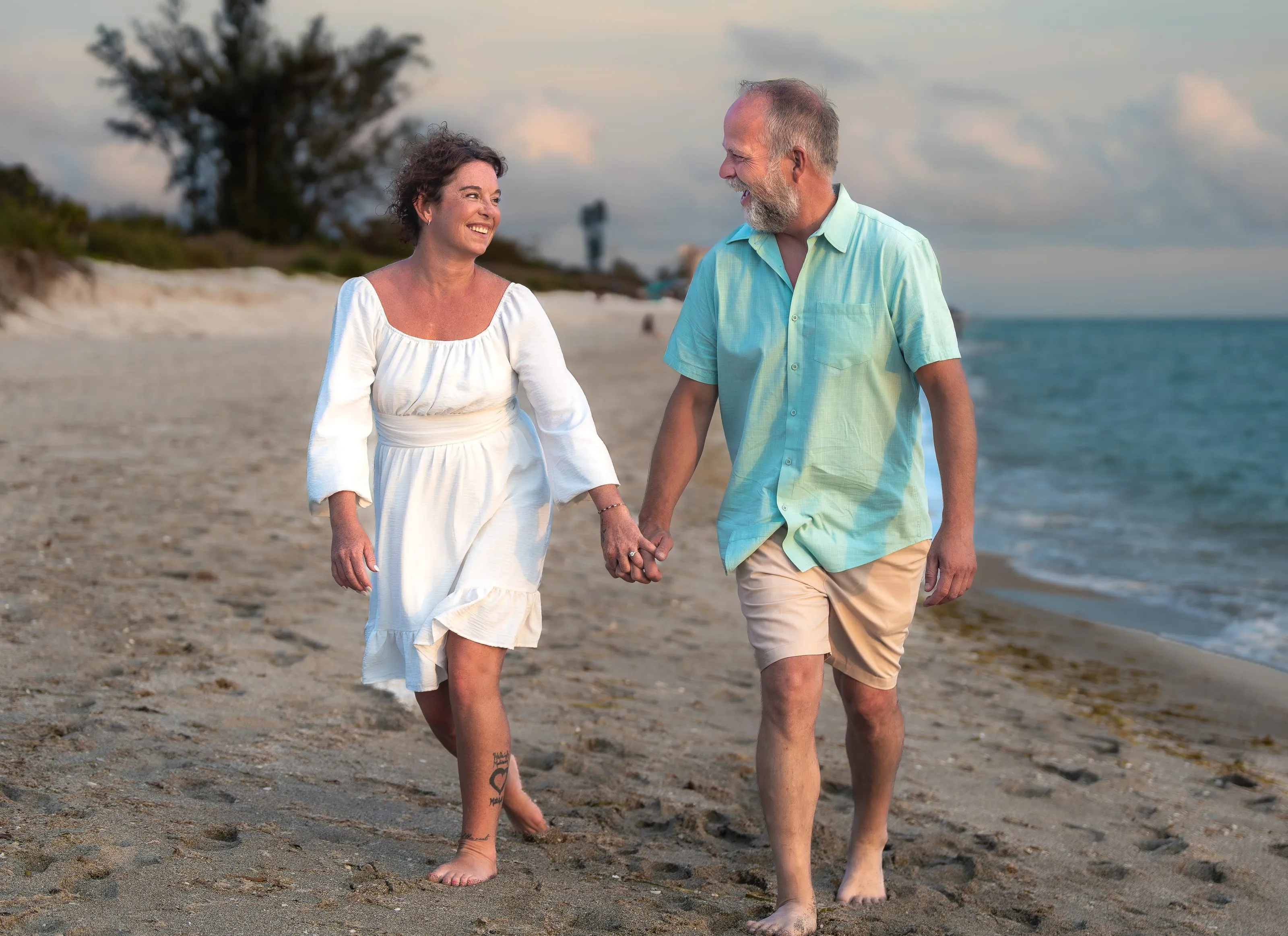Couple holding hands on a walk along the shoreline